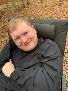 Dan Richey seated in a chair and smiling up at the camera